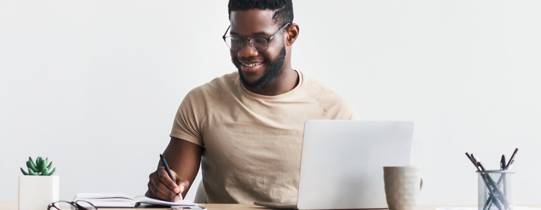 a man sitting at a desk with a laptop